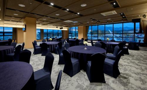 a conference room with tables and chairs and windows at Ramada by Wyndham Gangwon Sokcho in Sokcho