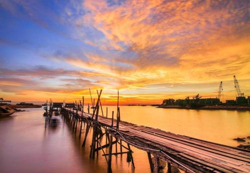 a dock on the water with a sunset in the background at OYO 91296 Nagoya Guesthouse in Nagoya