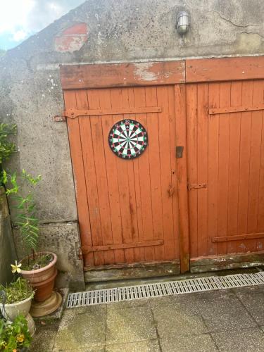 a red door with a dart board on it at maison de 100 m2 comprenant 3 chambres avec jardin in Dun-sur-Grandry