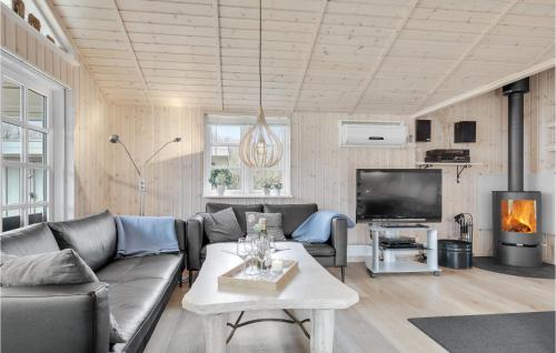 a living room with a couch and a tv at Holiday Home Bækholmen Ebeltoft I in Ebeltoft