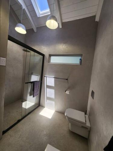 a bathroom with a toilet and a glass shower at House JDV 20 Rooipypie in St. Helena Bay