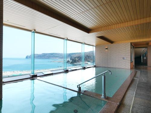 a large swimming pool with a view of the ocean at Kitakobushi Shiretoko Hotel & Resort in Shari