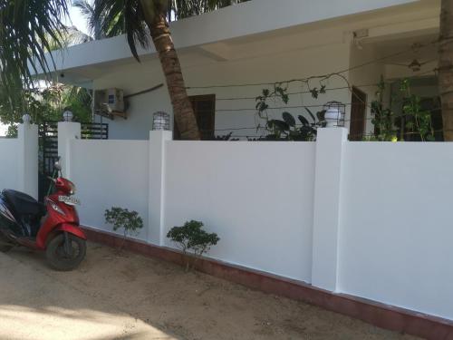 a scooter parked in front of a white fence at Surf reef beach in Trincomalee