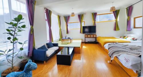 a bedroom with a bed and a couch and a table at Encounter Garden Great Wall Holiday Guesthouse in Beijing