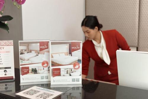 a woman is looking at a display of a mattress at Merlin Hotel in Sungai Kolok
