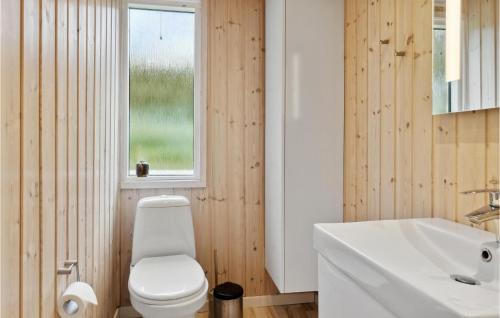 a bathroom with a white toilet and a sink at 5 Bedroom Nice Home In Hadsund in Hadsund