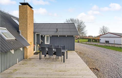 a table and chairs in front of a house at Nice Home In Hadsund With Sauna in Haslevgårde