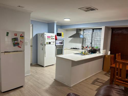a kitchen with a refrigerator and a counter top at Celia's lovely house in Perth