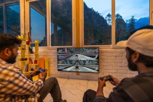 two men playing a video game on a tv at The Social Stays Kasol formerly ArtBuzz in Kasol