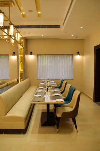 a dining room with a long table and chairs at Tulip Inn Shravasti in Katra