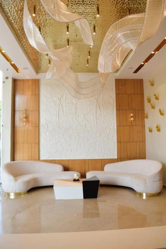 a room with two white beds and a ceiling at Tulip Inn Shravasti in Katra