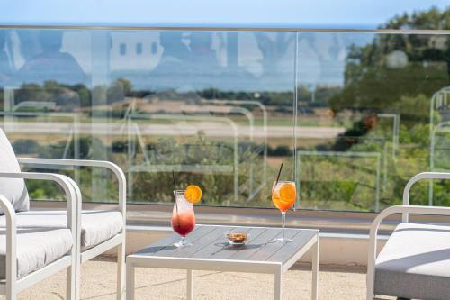 two drinks on a table in front of a window at Drita Studios & Apartments in Svoronata