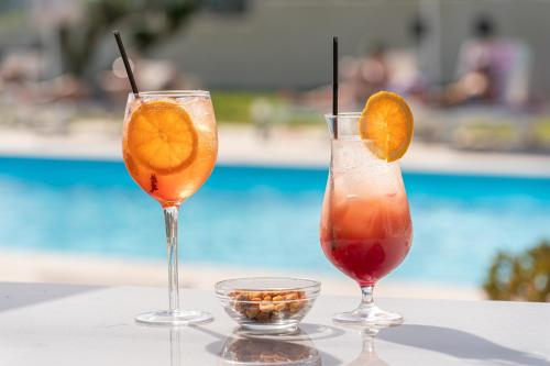 two cocktails sitting on a table next to a pool at Drita Studios & Apartments in Svoronata