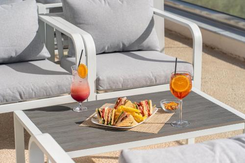 a table with a plate of food and two drinks at Drita Studios & Apartments in Svoronata