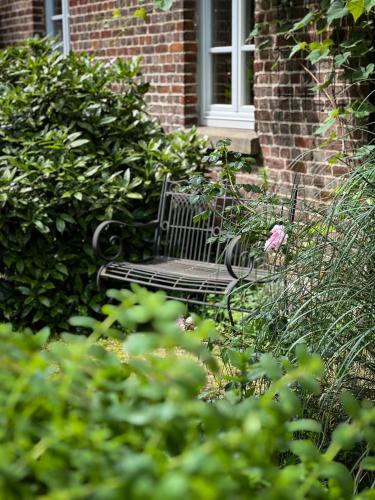 a black bench sitting in front of a brick building at B&B - Western Horse Academy in Walsrode