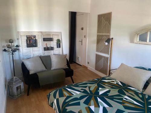 une chambre avec un lit, un canapé et une chaise dans l'établissement T2 confortable, à La Seyne-sur-Mer