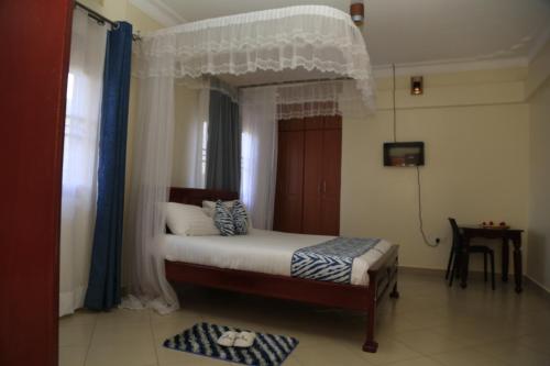 Postel nebo postele na pokoji v ubytování Jatheo Hotel Rwentondo