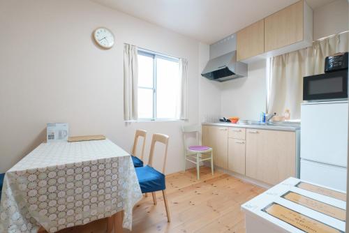 a kitchen with a table and a kitchen with a table and chairs at OHAYO Hotel 大森西 in Tokyo