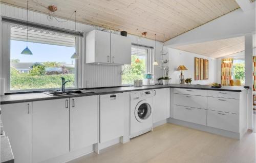 a kitchen with white cabinets and a washing machine at Nice Home In Roskilde With Wifi in Roskilde