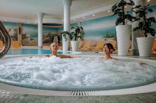 two women in a hot tub in a hotel at Arkona Strandhotel in Binz