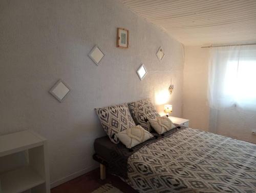 une chambre avec un lit avec un canapé et une fenêtre dans l'établissement Maison de village, à Sigean