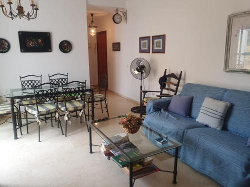 a living room with a blue couch and a table at Bogavante Costa Ballena in Rota