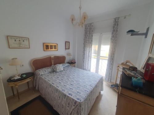 a bedroom with a bed and a table and a window at Bogavante Costa Ballena in Rota