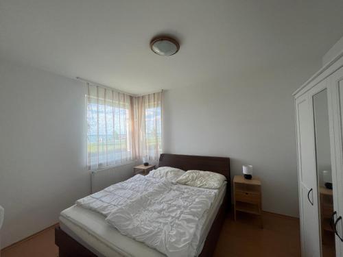 biała sypialnia z łóżkiem i oknem w obiekcie Summer Vibe Siofok 2 Ground floor w Siófoku