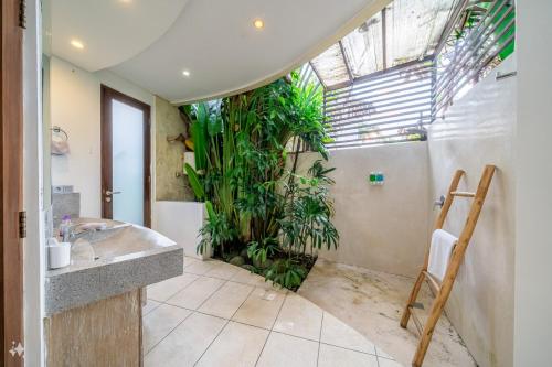 a bathroom with plants in the corner of the room at Villa Coccoos II Spacious 2BR Pererenan Canggu in Tumbak Bayuh