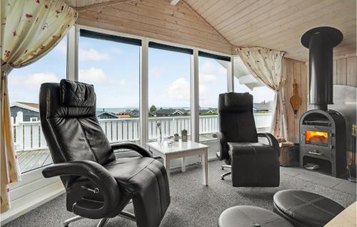 a living room with chairs and a wood stove at Holiday Home Bygmarken V in Sjølund