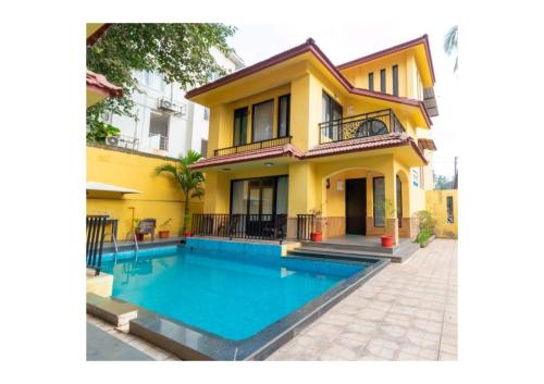 a house with a swimming pool in front of it at Lagoon Villa in Old Goa