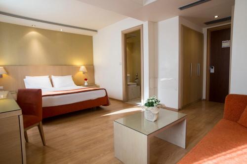 a hotel room with a bed and a couch at Davitel - Tobacco Hotel in Thessaloniki