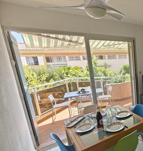 une salle à manger avec une table et des chaises sur un balcon dans l'établissement Studio Climatisé bord de Mer, à 100m de la plage du Verdon, à Martigues