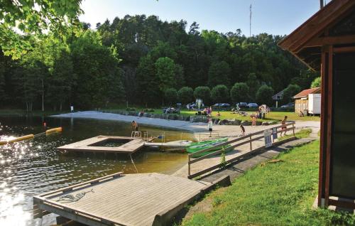 a dock in a body of water with people on it at Three-Bedroom Holiday Home In Tvedestrand in Tvedestrand