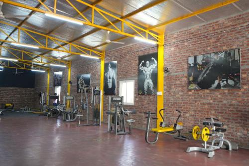 a gym with bikes and exercise equipment in a brick wall at Rustic Roots Farm Stay in Atāri