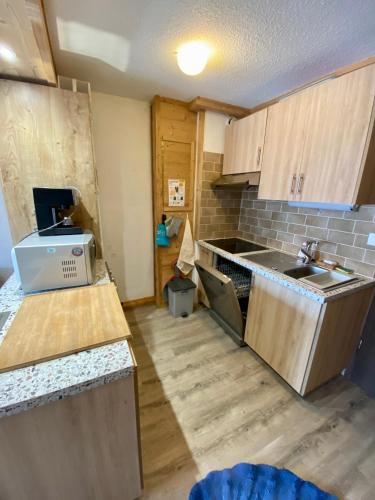 une cuisine avec un évier et un plan de travail dans l'établissement Appartement pied des pistes, à Taninges