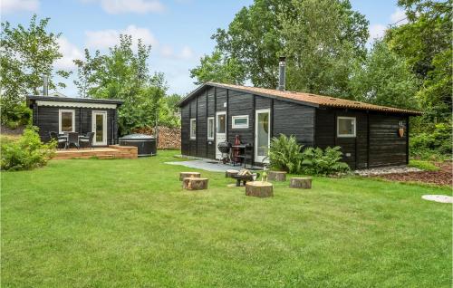 a black tiny house in a yard at 2 Bedroom Amazing Home In Kruså in Kruså
