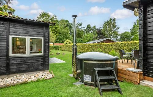 a small black house with a ladder in a yard at 2 Bedroom Amazing Home In Kruså in Kruså
