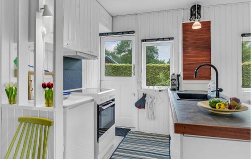 a kitchen with white counters and a sink and windows at 2 Bedroom Amazing Home In Kruså in Kruså