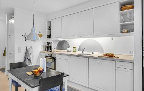 a kitchen with white cabinets and a table at Apartment Havnevej Nykøbing Sj V in Nykøbing Sjælland