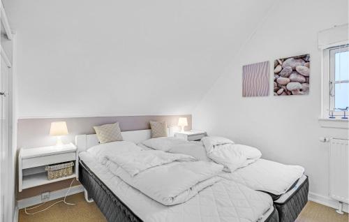 a white bedroom with a large bed with white sheets at Apartment Havnevej Nykøbing Sj V in Nykøbing Sjælland