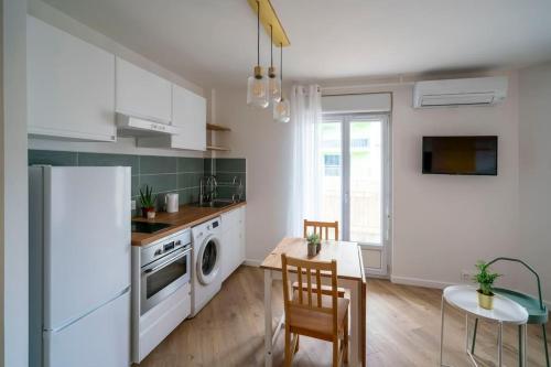 Il comprend une cuisine équipée d'un réfrigérateur blanc et d'une table avec des chaises. dans l'établissement Charmant T2 rénové lumineux à 15mins du vieux port, à Marseille