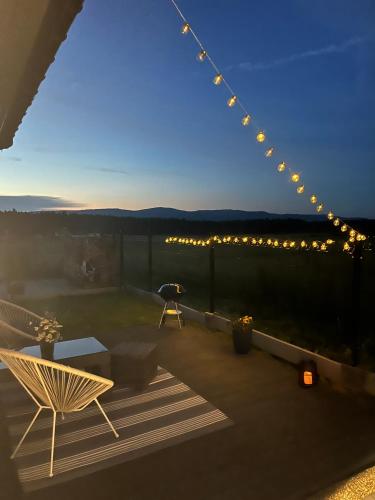 a balcony with a table and chairs and lights at Anielski Apartament z prywatną balią in Szaflary