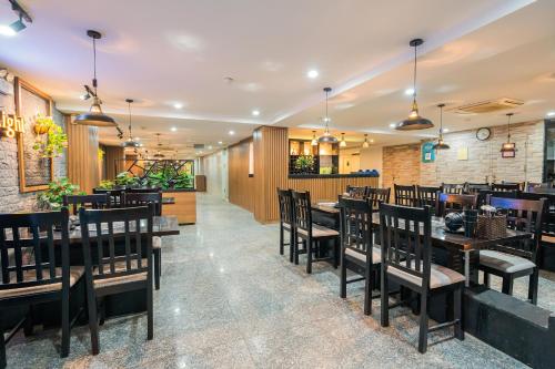 a dining room with wooden tables and chairs at Sunrise Hanoi Hotel in Hanoi