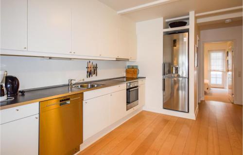 a kitchen with white cabinets and a stainless steel refrigerator at Apartment Bagenkop 27 in Bagenkop