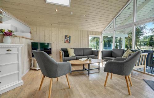 a living room with a couch and a table and chairs at Holiday Home Bæverstien V in Marielyst