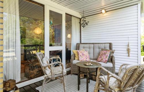 a porch with a couch and chairs and a table at Gorgeous Home In Otterup With Wifi in Otterup