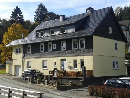 a large house with a black roof at Fewo In Schustes in Willingen