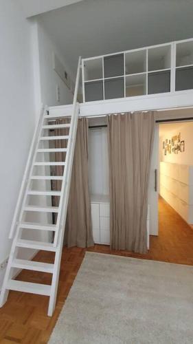 a white staircase in a room with a bedroom at Ein Traum im Herzen der Altstadt in Wetzlar