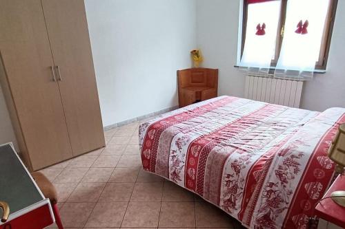a bedroom with a bed with a red and white blanket at Maison Lella in Pontey